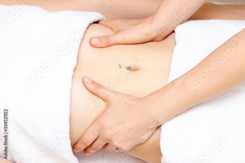 Massage Therapist Massaging a Womens Stomach. Massage and body care. Spa body massage woman hands treatment.