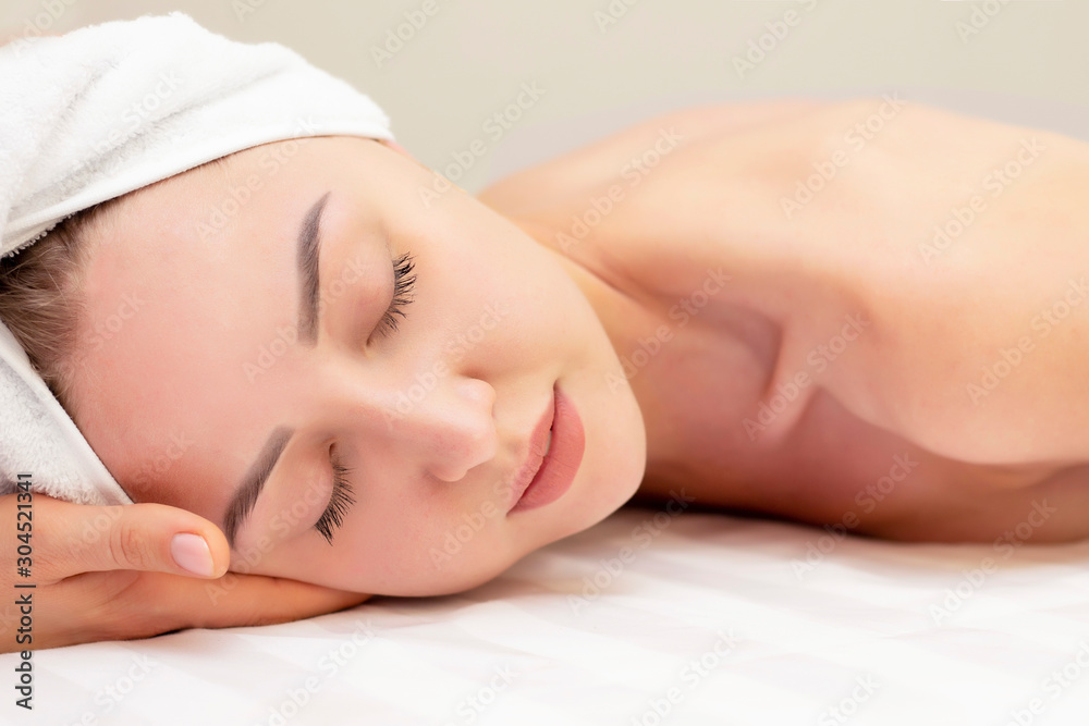 Young woman enjoying massage in spa salon. Closeup of young woman getting spa massage treatment at beauty spa salon.Spa skin and body care. Facial beauty treatment.Cosmetology. Young woman enjoying massage in spa salon. Closeup of young woman getting spa massage treatment at beauty spa salon.Spa skin and body care. Facial beauty treatment.Cosmetology.