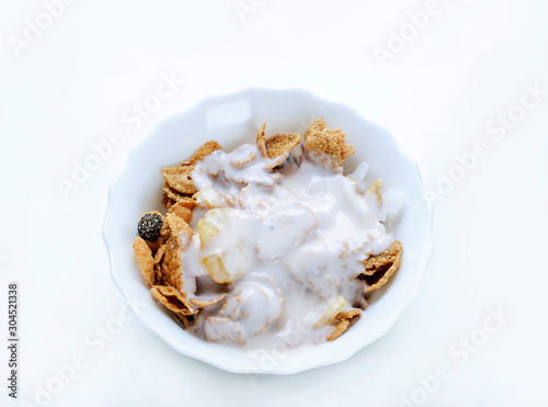Muesli breakfast cereal with yogurt in a white plate on a white background, diet, proper nutrition