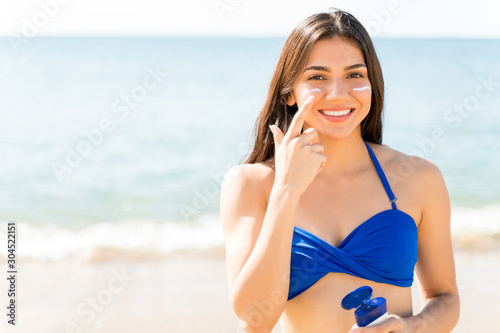 Woman Using Sunscreen At Beach