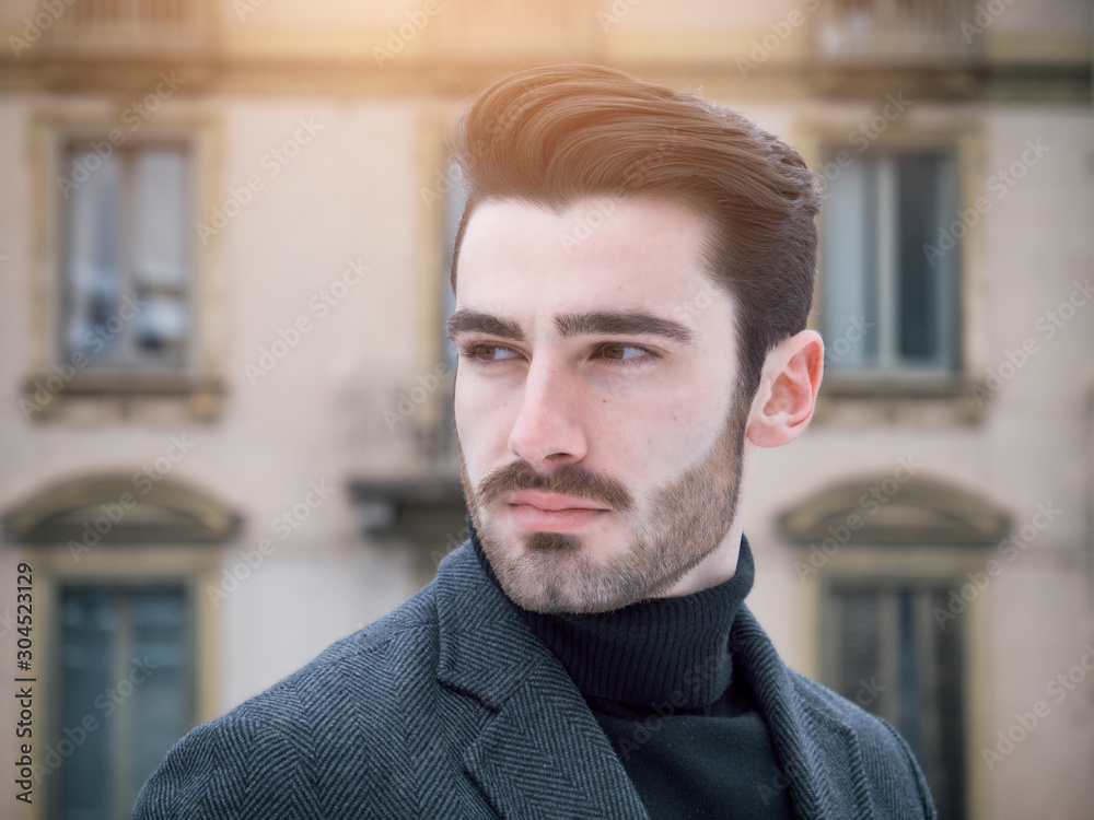 Handsome bearded young man outdoor in winter fashion, wearing black turtleneck sweater and woolen blazer jacket in city setting Handsome bearded young man outdoor in winter fashion, wearing black turtleneck sweater and woolen blazer jacket in city setting