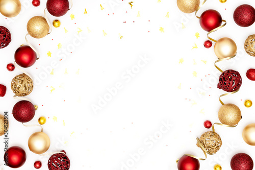 New Year and Christmas frame. Red and golden Christmas decorations - shiny balls, sparkles and decorative ribbon on white paper background. Top view, flat lay, copy space