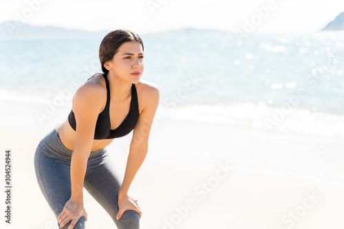 Tired Woman Resting After Training Session At Beach