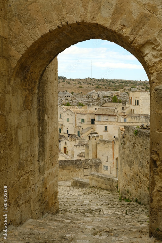 Matera in Italy, world heritage of humanity. Door with arch and houses built in tufa stone of beige color.