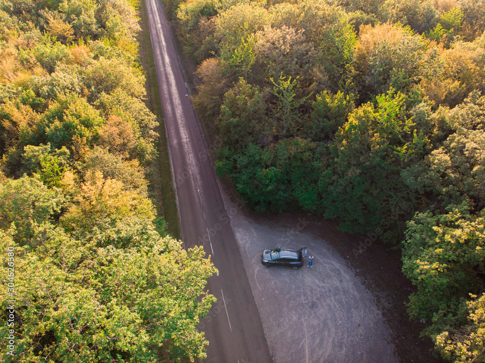 Fototapeta premium photo aérienne d'une route et d'une voiture garée vers la forêt