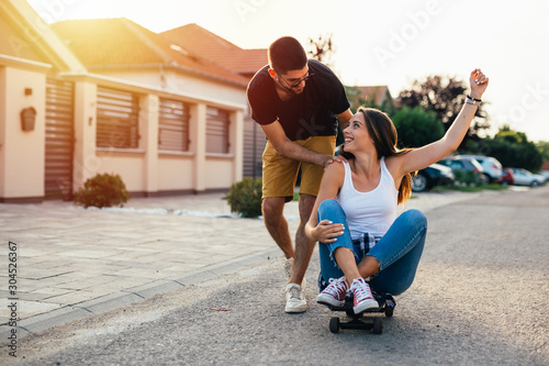 couple having fun outdoor driving skateboard