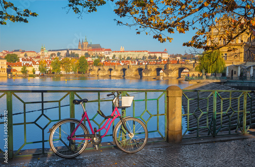 Prague - The rental bike on the waterfront,Charles Bridge, Castle and Cathedral in the background.