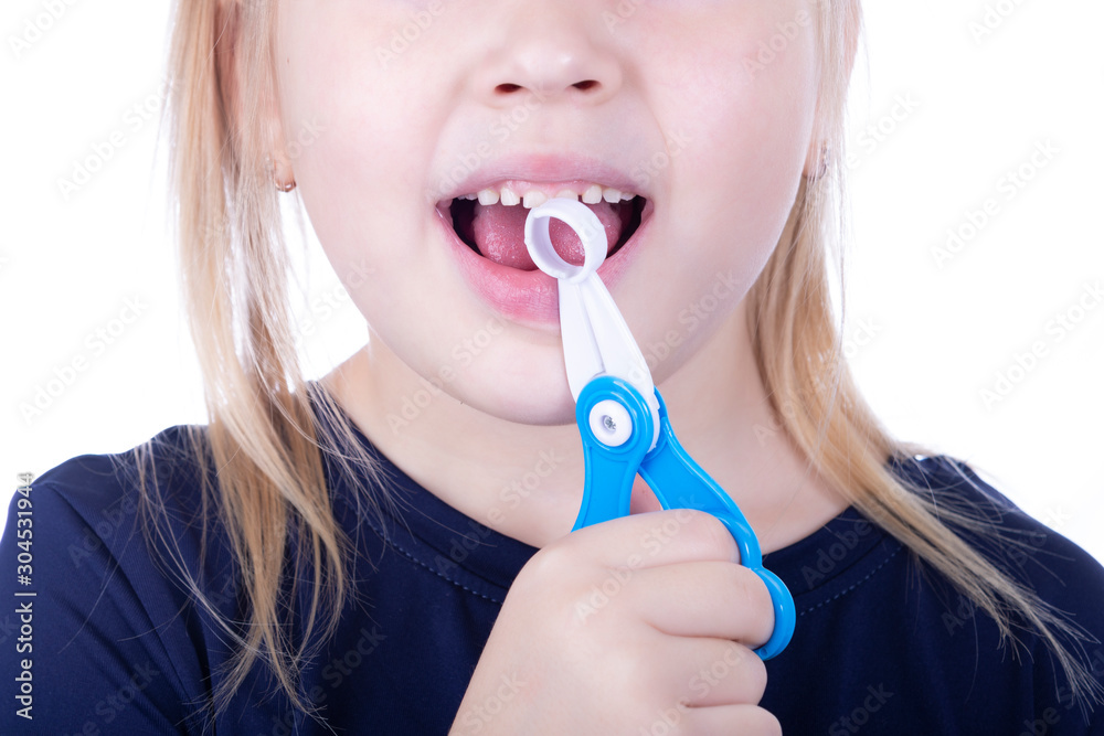 Little girl pull out a tooth with toy pliers on a white background