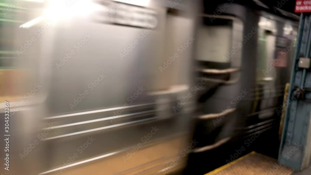 Blurred view of fast moving train in New York City subway station