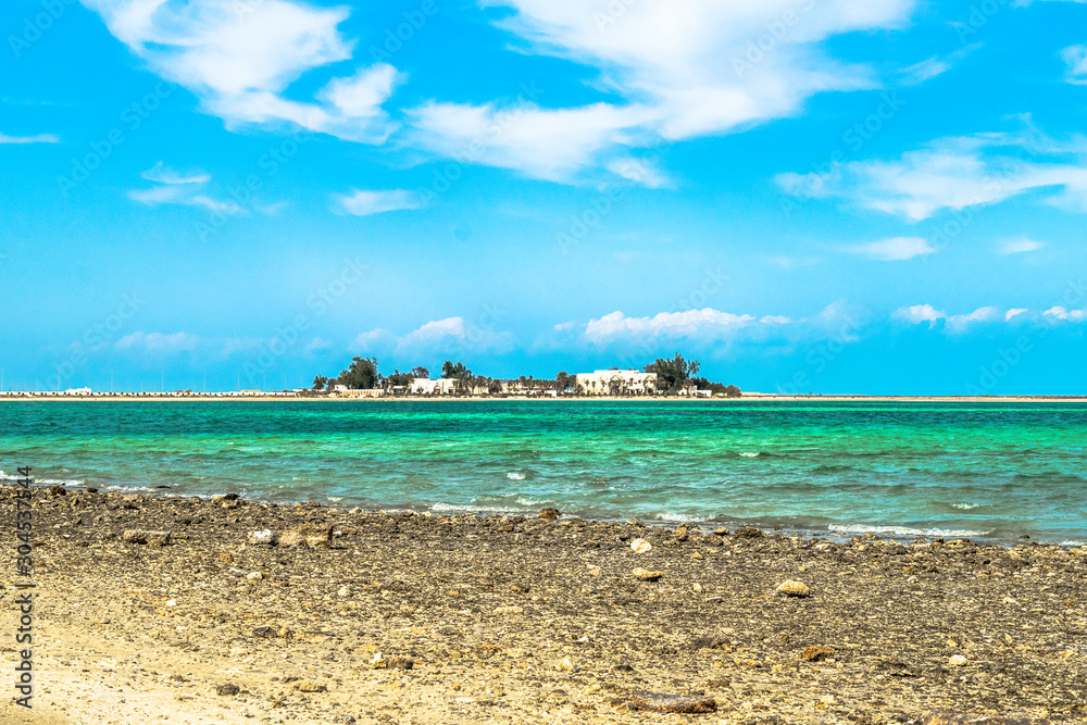 Fototapeta premium beautiful and bright pleasant day at a beach and an island in the background 