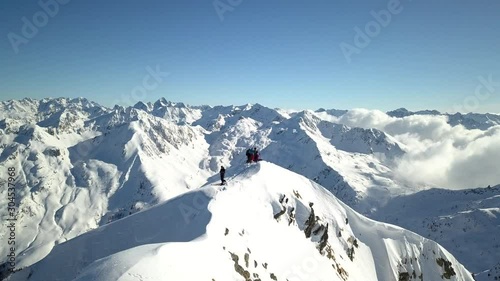 4k aerial orbit drone footage flying around  the snowy mountain peaks of Tartano Valley in Sondrio province, italian mountains in the central alps with presence of alpinists on top.