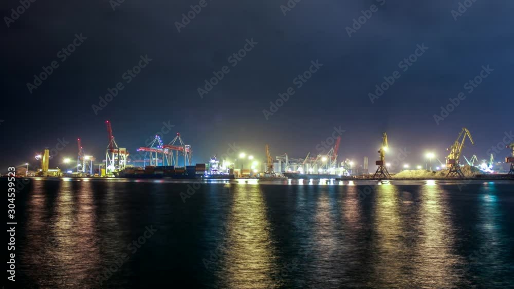 Time laps. China. Cargo operation with bulk carrier vessel moored at pier. Big cargo terminal at seaport. Cereals bulk transshipment from road transport to vessel at night. Agricultural products trans Time laps. China. Cargo operation with bulk carrier vessel moored at pier. Big cargo terminal at seaport. Cereals bulk transshipment from road transport to vessel at night. Agricultural products trans