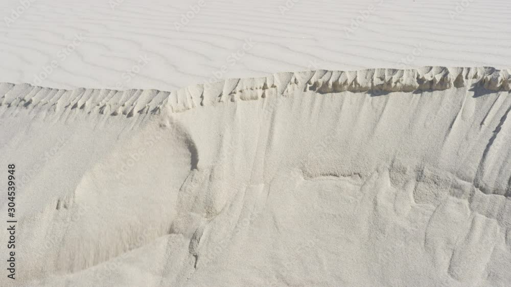Various angles of sand erosion as a desert dune collapses in slow motion. Climate change & sands of time. Filmed on RED Camera.