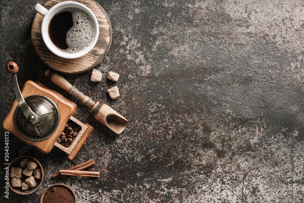 Coffee cup with coffee grinder and coffee beans on dark textured background. Coffee cup with coffee grinder and coffee beans on dark textured background.