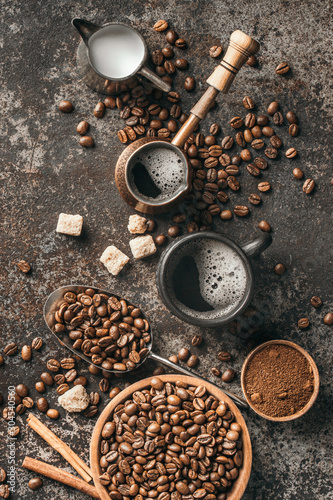 Fotografija Coffee cup, sugar, milk and coffee beans on dark background.