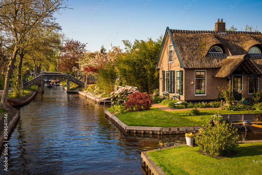 Beautiful landscape with canal, boats and picturesque houses, Giethoorn, Netherlands Beautiful landscape with canal, boats and picturesque houses, Giethoorn, Netherlands