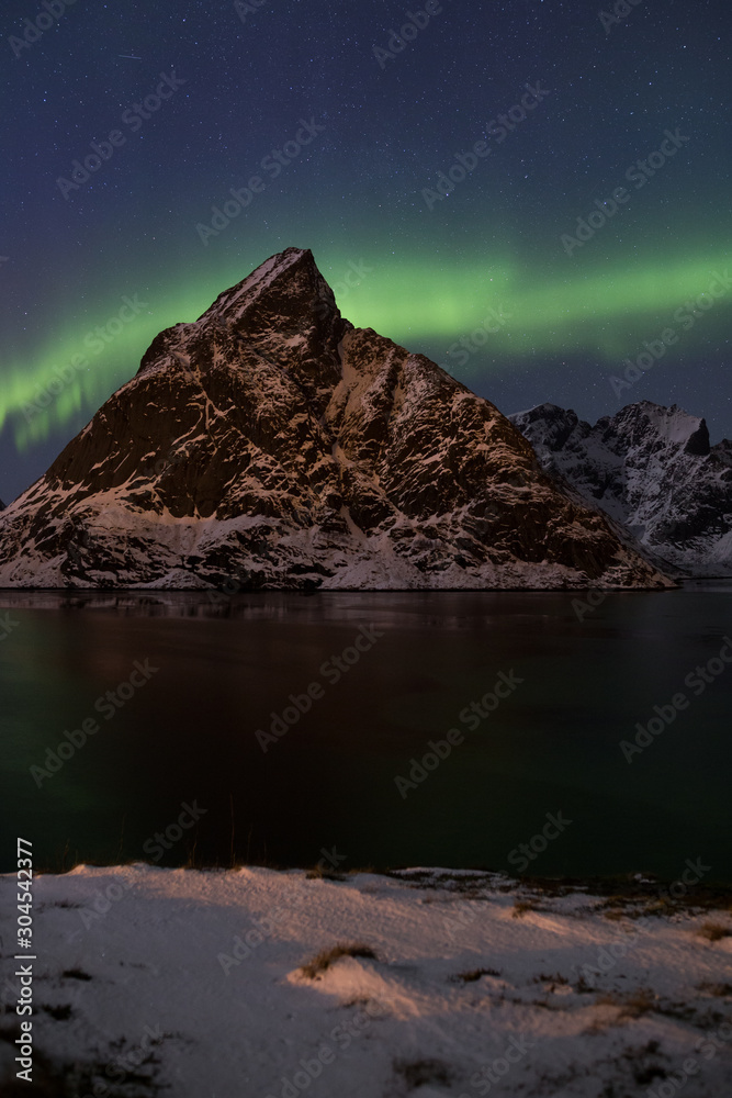 Naklejka premium Northern light display over Reinefjorden (Lofoten) in winter