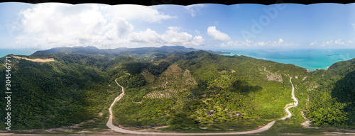 360-degree panoramic aerial view without sky on the road leading to the sea between the hills of Koh Phangan Island. Thailand