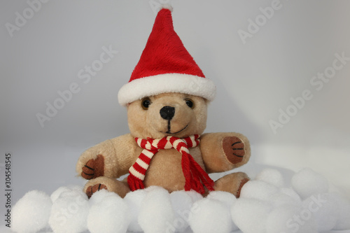 Christmas bear between snowballs with Santa hat