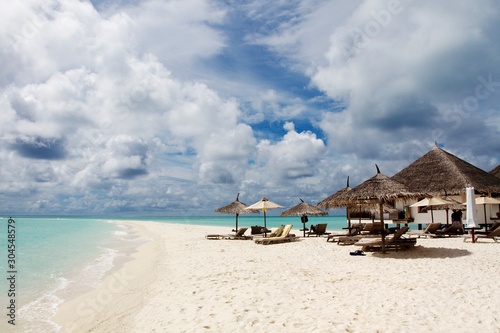 Sun umbrellas and chairs in a white sand beach of Maldives  © Soldo76