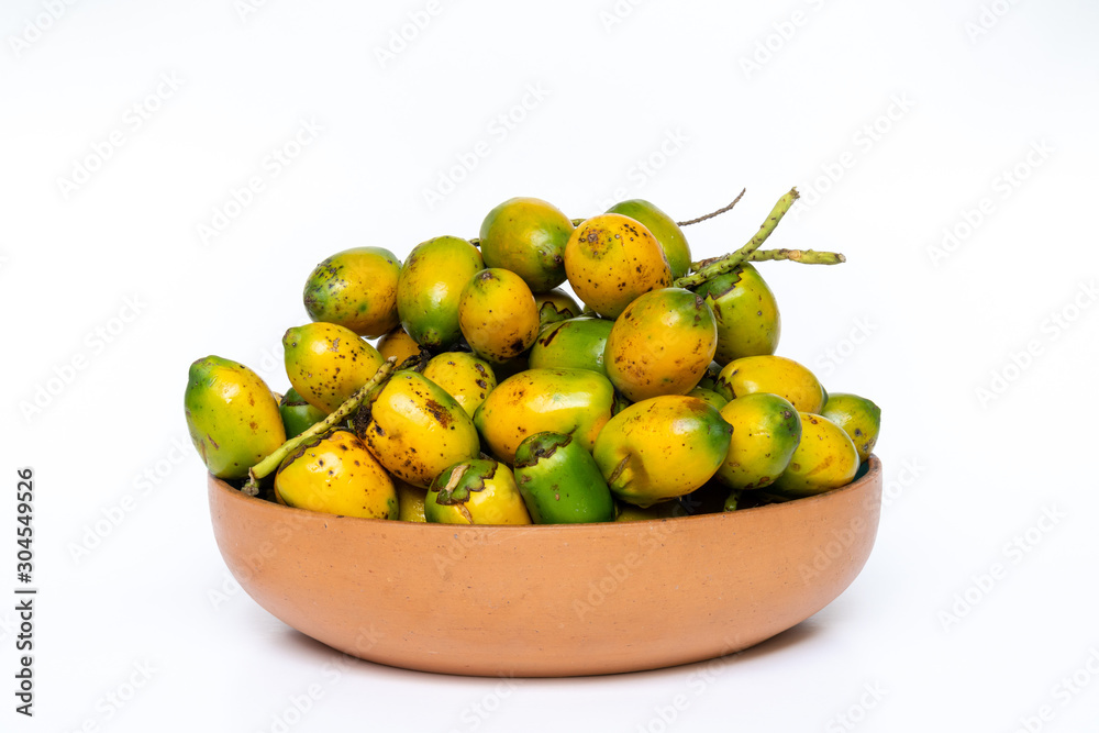Pottery bowl with ripe and delicious pupunha palm fruit (Bactris gasipaes), harvested from the Amazon rainforest, isolated on white background. Concept of healthy eating, health, cooking and nature. Pottery bowl with ripe and delicious pupunha palm fruit (Bactris gasipaes), harvested from the Amazon rainforest, isolated on white background. Concept of healthy eating, health, cooking and nature.