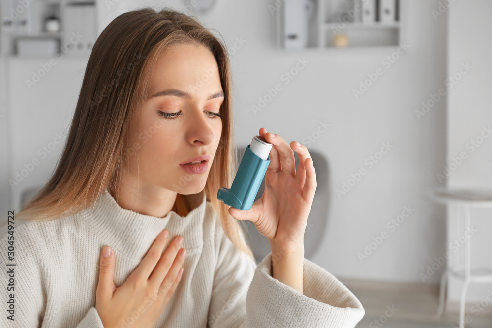 Young woman with inhaler having asthma attack at home Young woman with inhaler having asthma attack at home