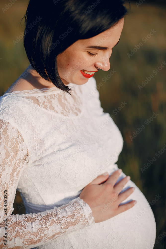 Pragnant woman. Lady in a field. Mother in a white dress Pragnant woman. Lady in a field. Mother in a white dress