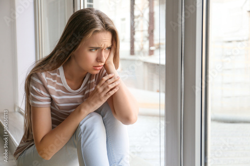 Depressed woman near window at home Free Download Depressed woman near window at home - GFXLoad