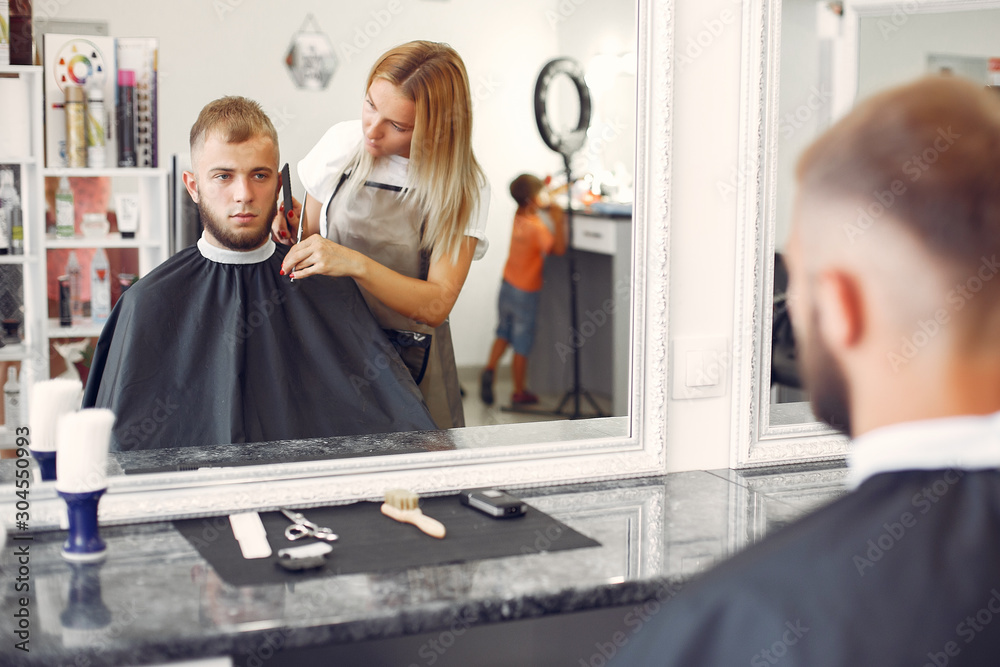 Man with a beard. Hairdresser with a client. Woman with scissors and a comb Man with a beard. Hairdresser with a client. Woman with scissors and a comb
