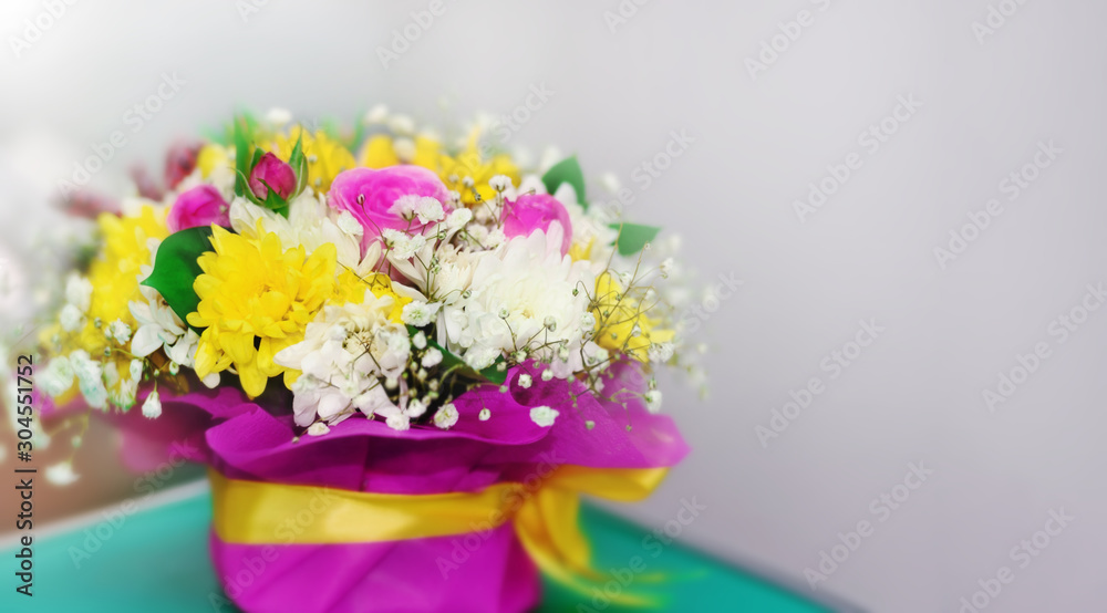Bouquet of bright flowers in a vase for the holiday. Blurred background.