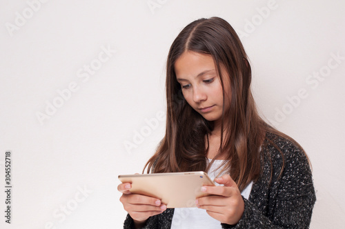 Young girl has the tablet in hand, she is looking at the tablet,