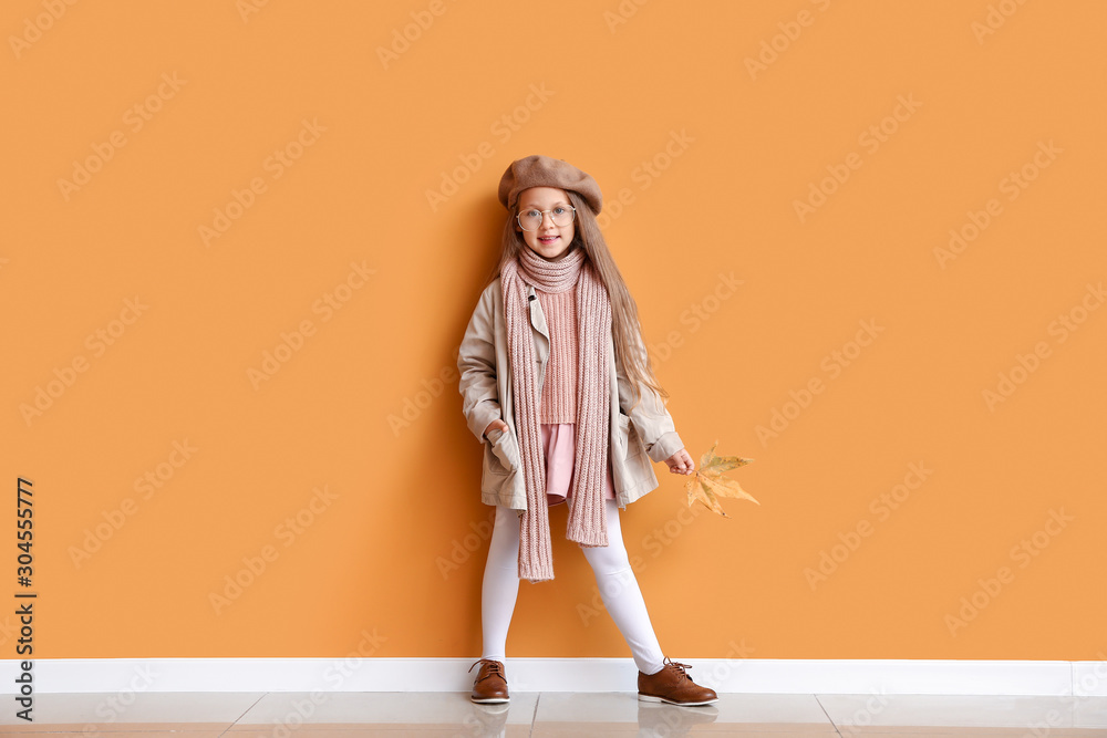 Fashionable little girl in autumn clothes near color wall Fashionable little girl in autumn clothes near color wall