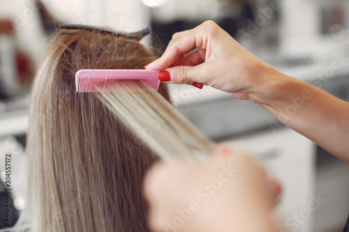 Hairdresser working with hear her client. Woman in a hair salon