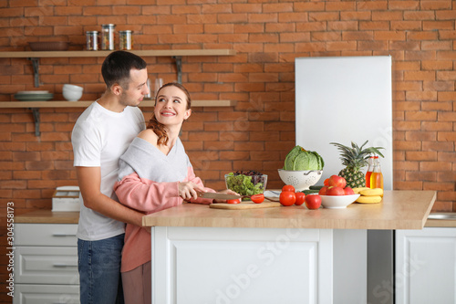 Beautiful young couple cook...