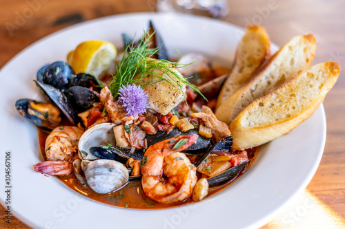 Bouillabaisse Seafood Soup Close-Up with Shrimp, Muscles, Clams, Fish, Fennel and Grilled Bread photo