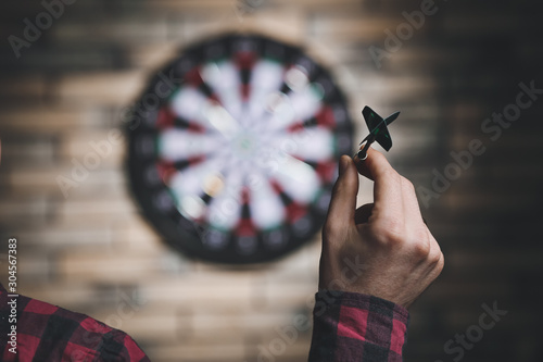 Fotografie Young man playing darts indoors