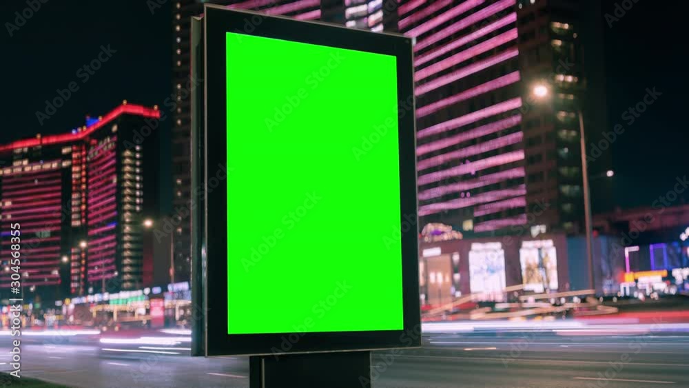 Modern billboard with a green screen on a busy highway with traffic, neon lights, timelapse of traffic at night, Moscow, Russia