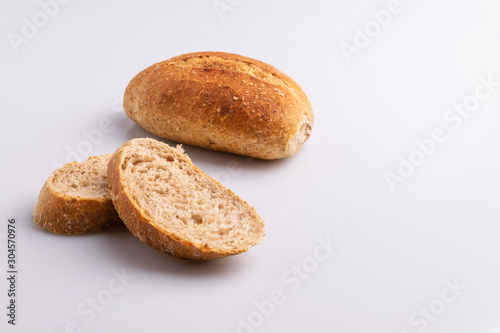 Wholegrain "French bread", traditional Brazilian bread in a white plate on white background, copy space,