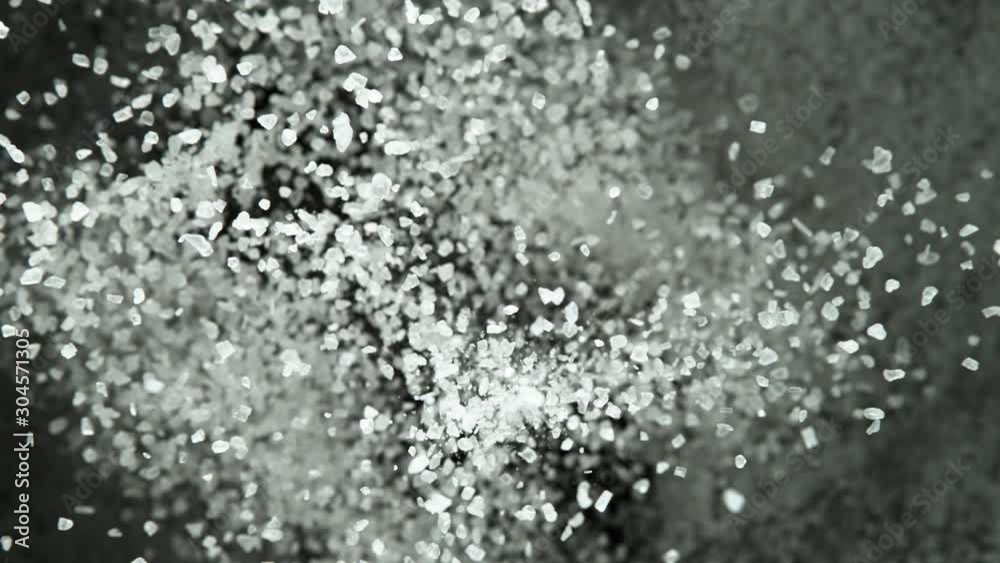 Super slow motion of flying whole grained salt pieces on black background. Filmed on high speed cinema camera, 1000 fps Super slow motion of flying whole grained salt pieces on black background. Filmed on high speed cinema camera, 1000 fps
