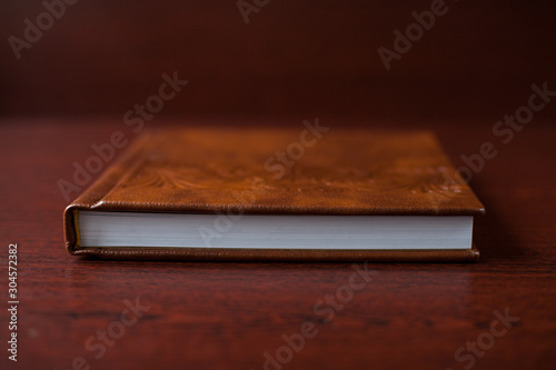 Elegant brown book with beautiful pattern. Wedding photobook. Wedding photo album