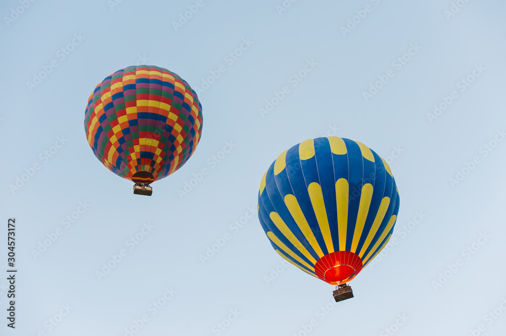 Fototapeta premium Many colorful hot air balloons flight above mountains - panorama of Cappadocia at sunrise. Wide landscape of Goreme valley in Cappadocia - billboard background for your travel concept in Turkey.