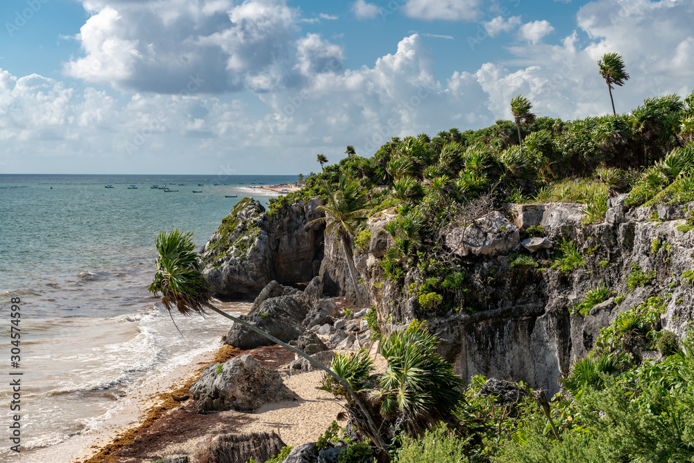 Beautiful beach in Tulum Mexico, Mayan ruins on top of the cliff.