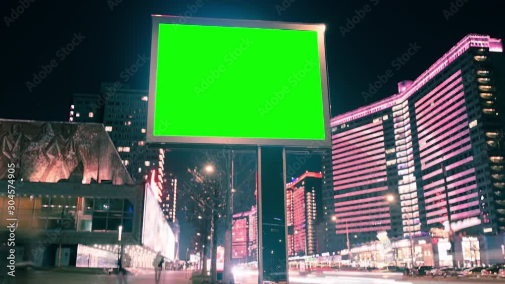 Modern billboard with green screen for advertising on a busy street with neon lights, blank billboard opposite the road, timelapse of traffic on busy highway, cyberpunk colors