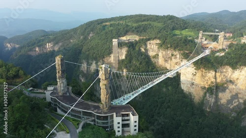 Aerial drone flight towards spectacular glass suspension bridge near Zhangjiajie national park, tourism and engineering in stunning mountain landscape in China photo