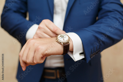 Man checks the time on his watch. The clock in his hands. Time run. Accuracy. What time is it?  photo