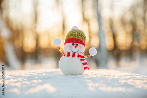 Snowman in winter wonderland scene. Christmas, New Year postcard design. Wintertime magic. Snowman in december snow at sunset © Miramiska