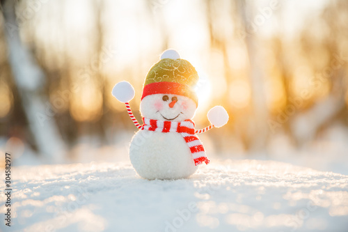 Snowman in winter wonderland scene. Christmas, New Year postcard design. Wintertime magic. Snowman in december snow at sunset photo