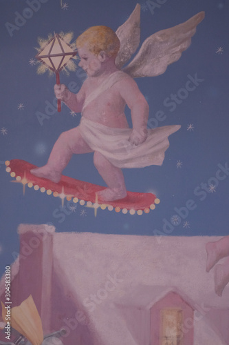 Little child angel on sketchboard holds a lamp photo