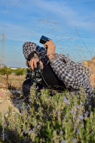 photographer man working orienting the flash in the field in a photo session on a sunny day photo