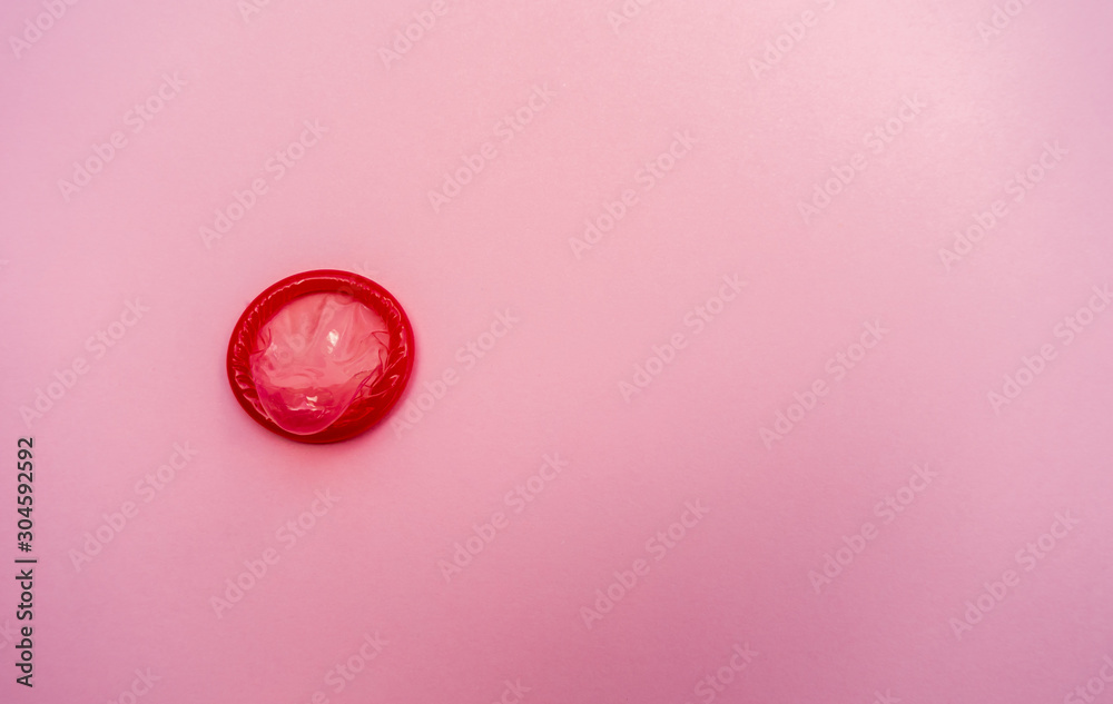 condom on a pink background. The concept of safe sex.